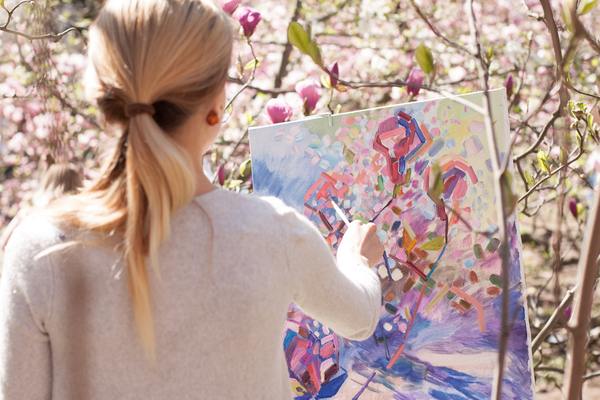 A lady painting a canvas outdoor