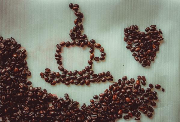 A close up photo of coffee beans used to create art shapes