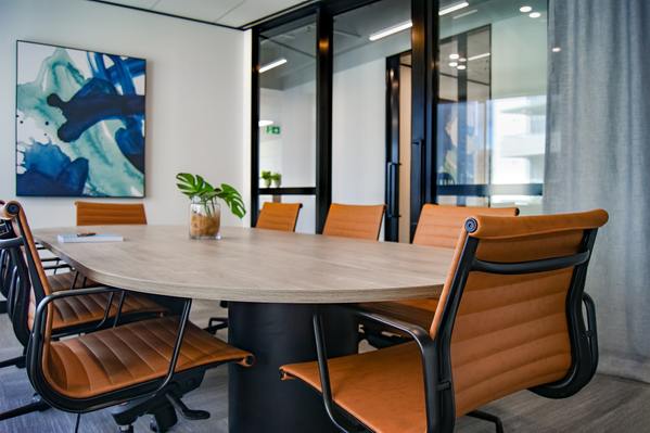 A photo of a brown wooden 9 piece office table and chairs