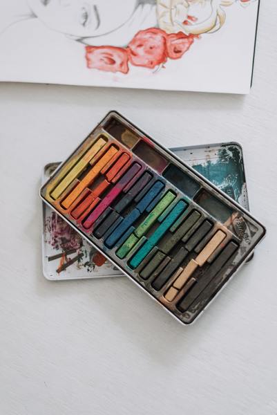 A photo of a set of crayons on a white platform in an art studio
