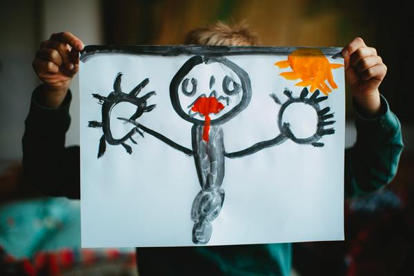 A photo of a toddler holding a drawing painting