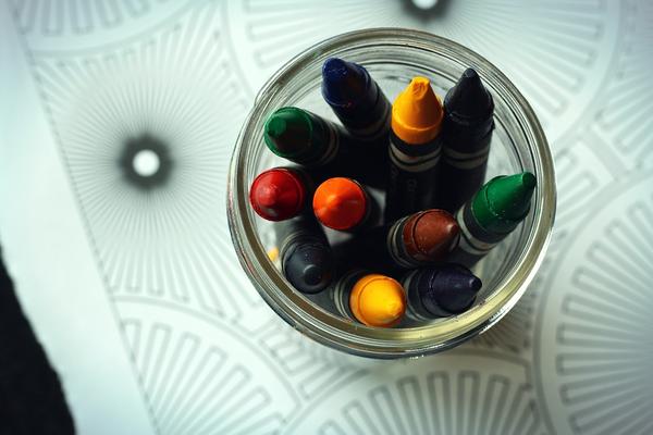 A photo of various colors of crayons in a jar